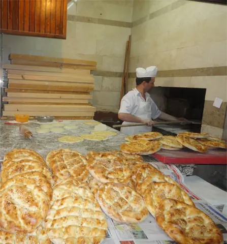 Fırın önünde usta ve tezgâhta taze pideler